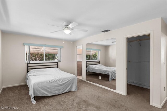 bedroom with visible vents, a spacious closet, carpet flooring, and multiple windows