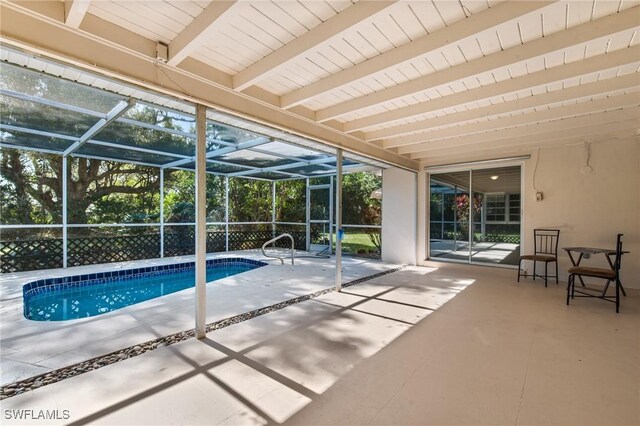 outdoor pool featuring glass enclosure and a patio area