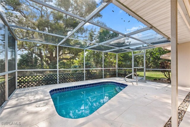 outdoor pool featuring glass enclosure and a patio