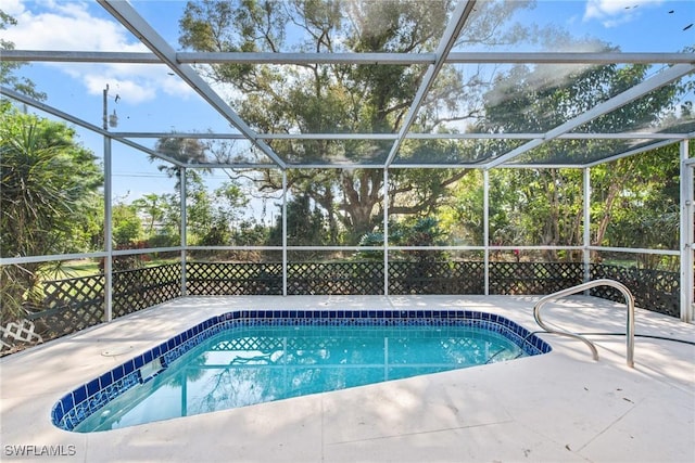 outdoor pool with glass enclosure and a patio