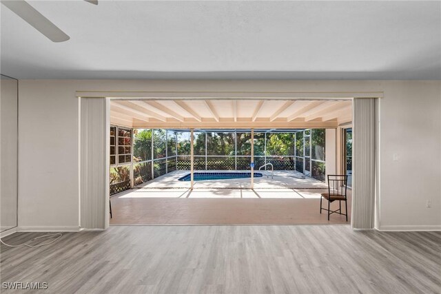 entryway with wood finished floors, a sunroom, and baseboards