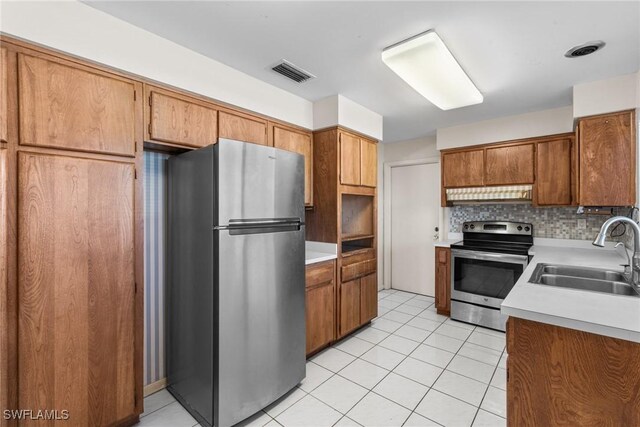 kitchen featuring stainless steel appliances, light countertops, visible vents, backsplash, and a sink