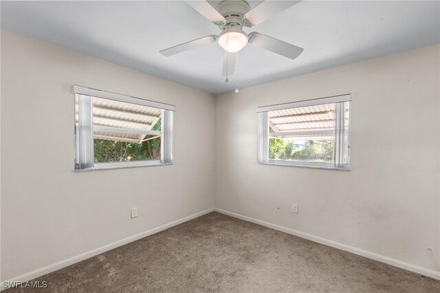 unfurnished room with carpet, a ceiling fan, and baseboards