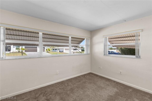 empty room featuring carpet floors and baseboards