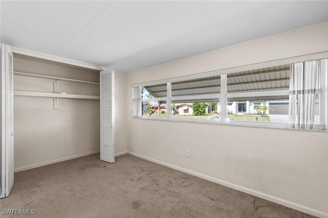 unfurnished bedroom with a closet, carpet flooring, and baseboards