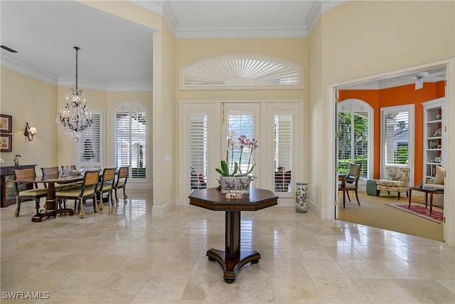 entryway featuring a notable chandelier, baseboards, and crown molding