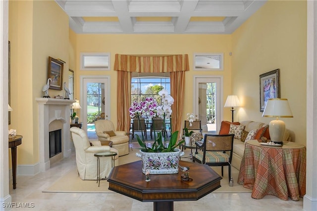 sitting room featuring a high ceiling, beamed ceiling, coffered ceiling, and a fireplace