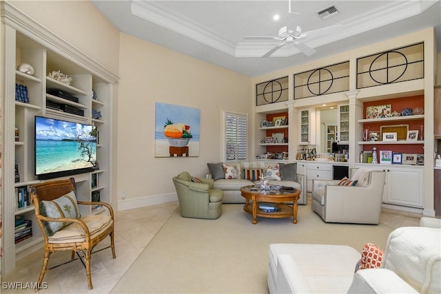 living area featuring ceiling fan, built in shelves, visible vents, ornamental molding, and a raised ceiling