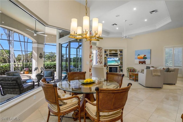 dining area with ceiling fan with notable chandelier, a raised ceiling, visible vents, and crown molding