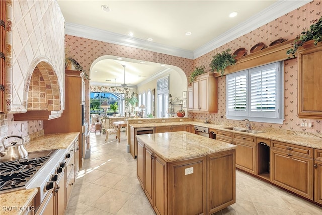 kitchen featuring a kitchen island, sink, light stone counters, stainless steel appliances, and crown molding