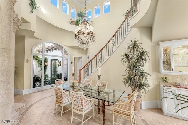 dining area featuring light tile patterned flooring, a towering ceiling, and a chandelier