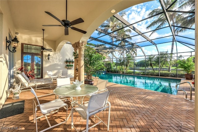 view of pool with ceiling fan, a lanai, and a patio