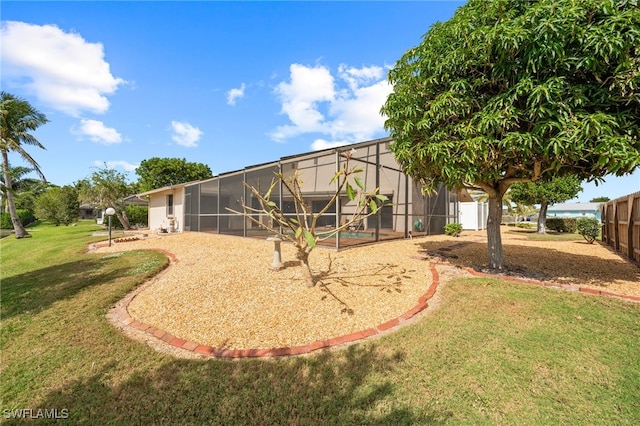 rear view of property with a lawn and a lanai