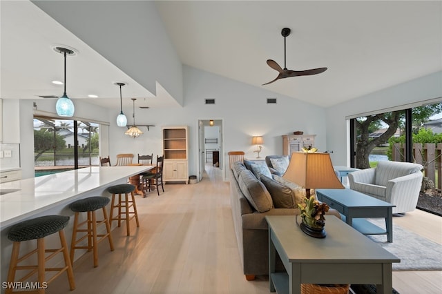 living room with ceiling fan, a wealth of natural light, high vaulted ceiling, and light hardwood / wood-style floors