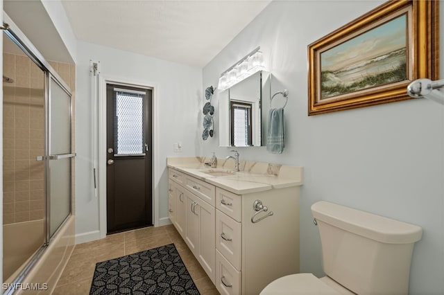 full bathroom featuring toilet, tile patterned floors, combined bath / shower with glass door, and vanity