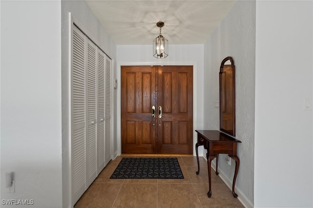 tiled entrance foyer featuring a chandelier