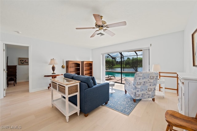 living room with ceiling fan and light hardwood / wood-style flooring