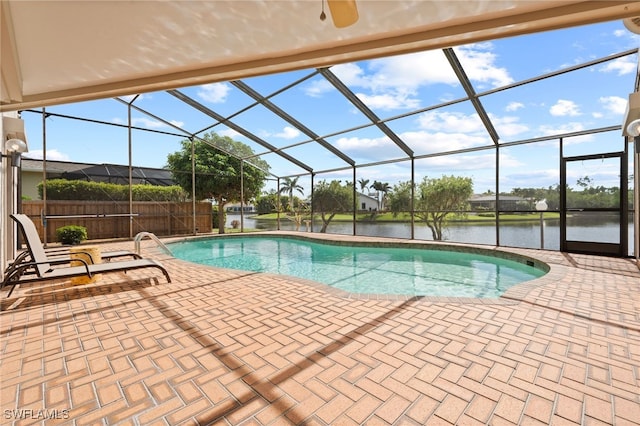 view of pool with a patio, a lanai, and a water view