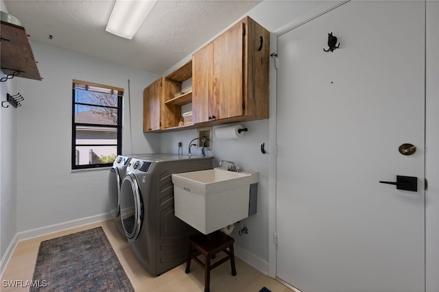 laundry area with sink, washer and dryer, and cabinets