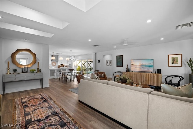 living area with a skylight, wood finished floors, visible vents, and recessed lighting