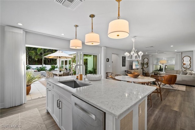 kitchen with visible vents, open floor plan, wood finished floors, stainless steel dishwasher, and a sink