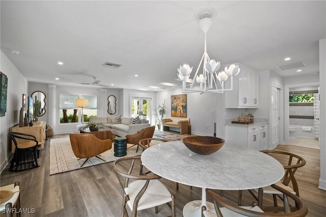 dining room featuring light wood-style floors, baseboards, visible vents, and recessed lighting