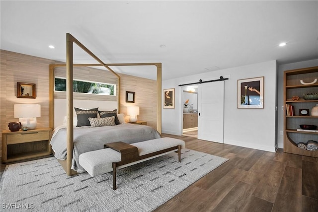 bedroom featuring baseboards, a barn door, wood finished floors, and recessed lighting