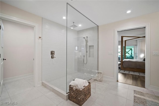 bathroom with recessed lighting, ensuite bathroom, tile patterned flooring, baseboards, and walk in shower