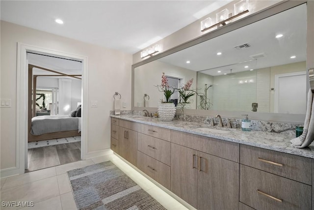 ensuite bathroom featuring tile patterned floors, visible vents, a sink, and double vanity