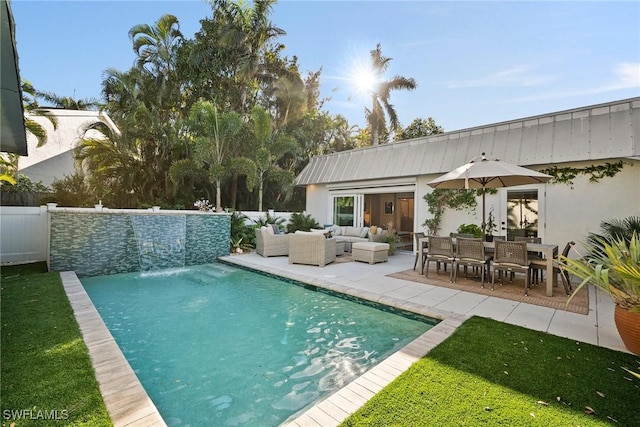 pool with a patio area, fence, and an outdoor living space