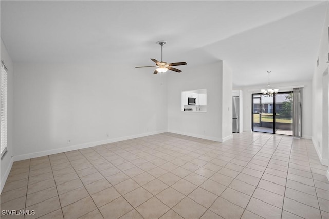 tiled spare room featuring lofted ceiling and ceiling fan with notable chandelier