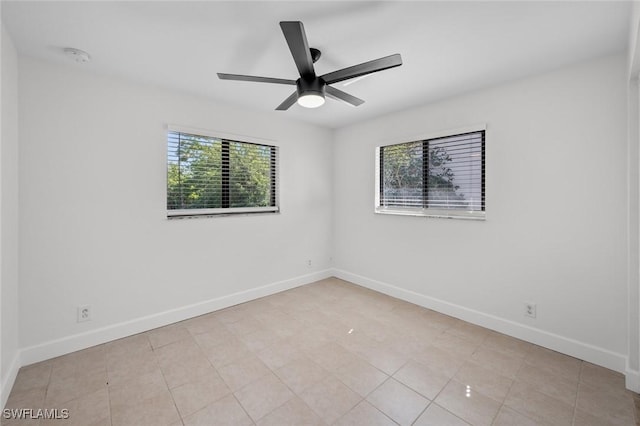 spare room featuring ceiling fan and a wealth of natural light