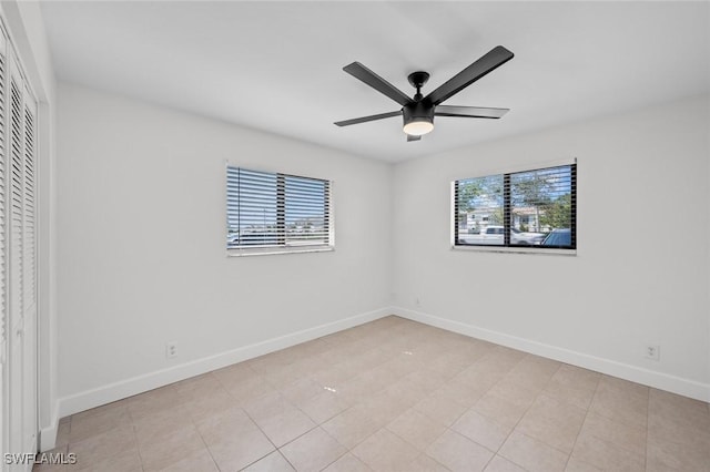 spare room featuring light tile patterned floors and ceiling fan