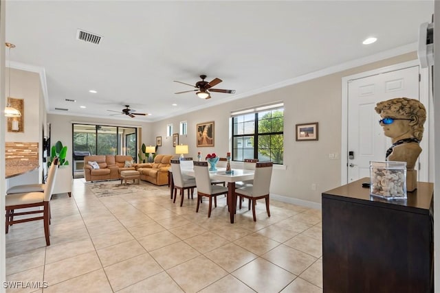 dining space with ornamental molding and light tile patterned floors