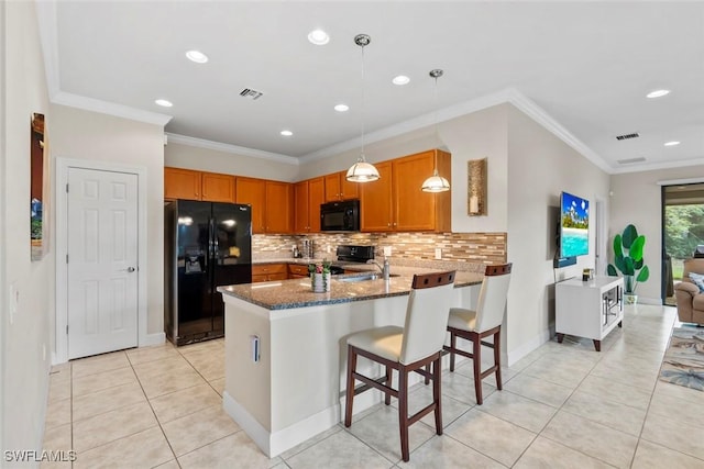 kitchen featuring stone counters, black appliances, backsplash, hanging light fixtures, and kitchen peninsula