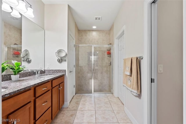 bathroom with walk in shower, vanity, and tile patterned flooring