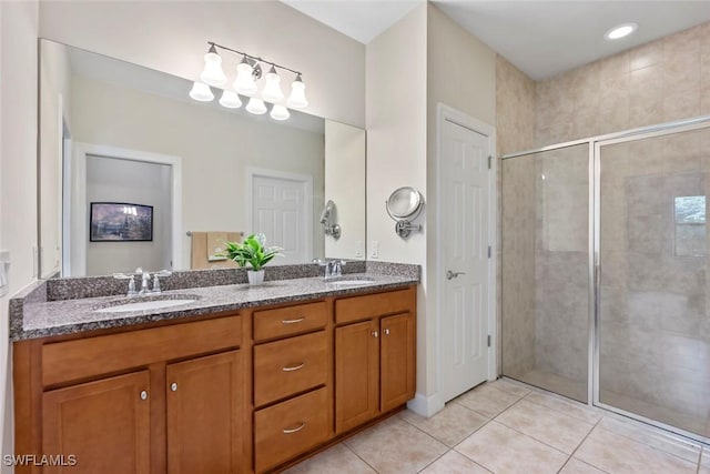 bathroom featuring tile patterned flooring, vanity, and a shower with shower door