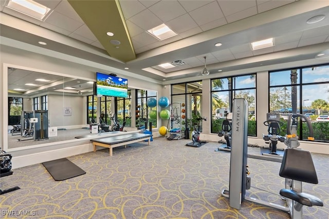 gym featuring a paneled ceiling and a tray ceiling