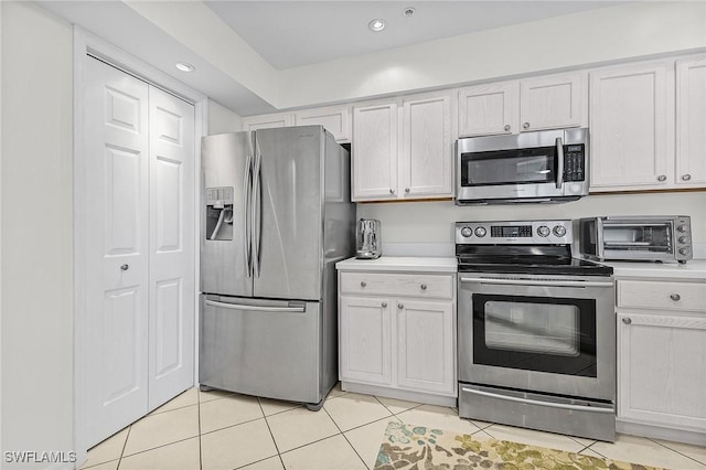 kitchen featuring white cabinetry, appliances with stainless steel finishes, and light tile patterned floors