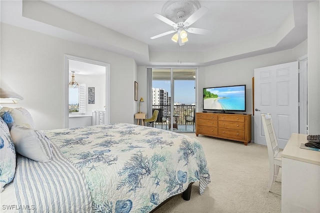 bedroom with light colored carpet, access to exterior, ceiling fan, a raised ceiling, and ensuite bath