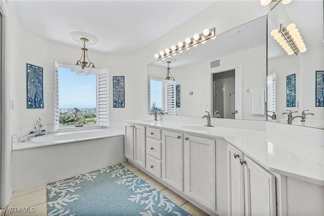 bathroom with a washtub, vanity, and tile patterned floors