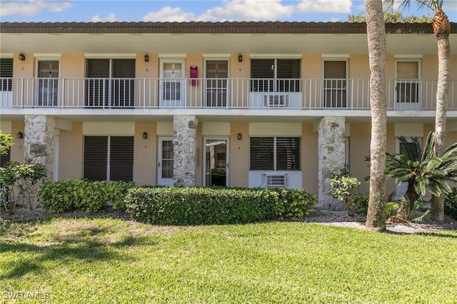 multi unit property with a front yard and stucco siding