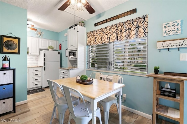 dining room featuring a textured ceiling, ceiling fan, baseboards, and wood tiled floor