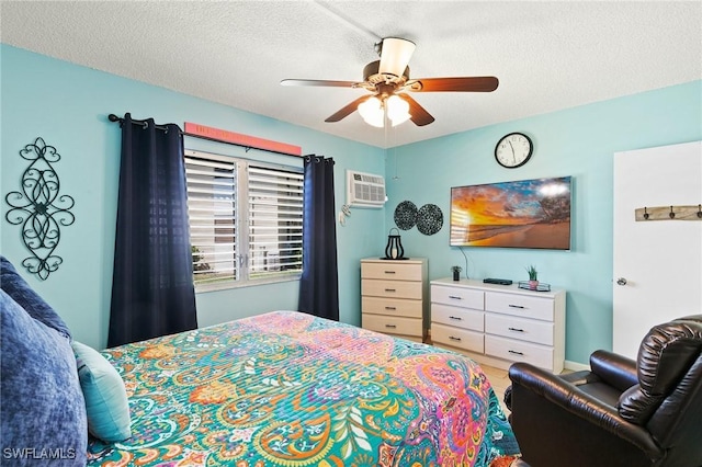 bedroom with a wall unit AC, a ceiling fan, and a textured ceiling