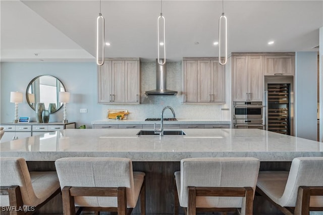 kitchen featuring a spacious island, beverage cooler, sink, and light stone counters