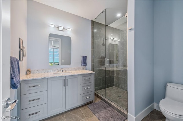 bathroom with vanity, a shower with door, and toilet