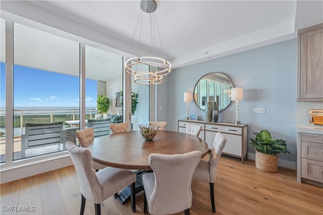dining area featuring an inviting chandelier and light hardwood / wood-style flooring