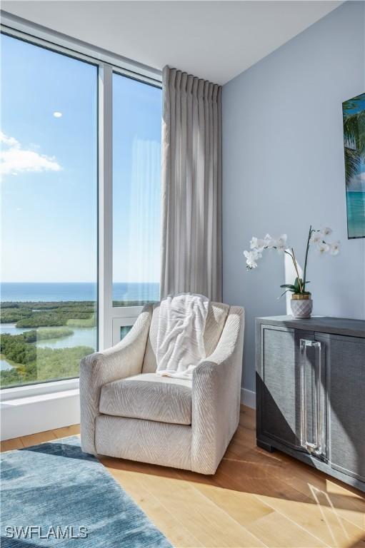 sitting room featuring a water view and light hardwood / wood-style flooring