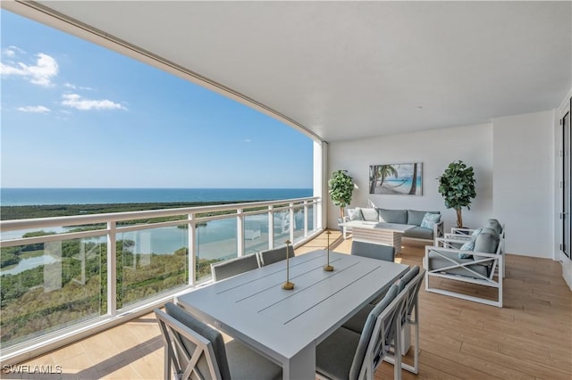 balcony with an outdoor living space and a water view
