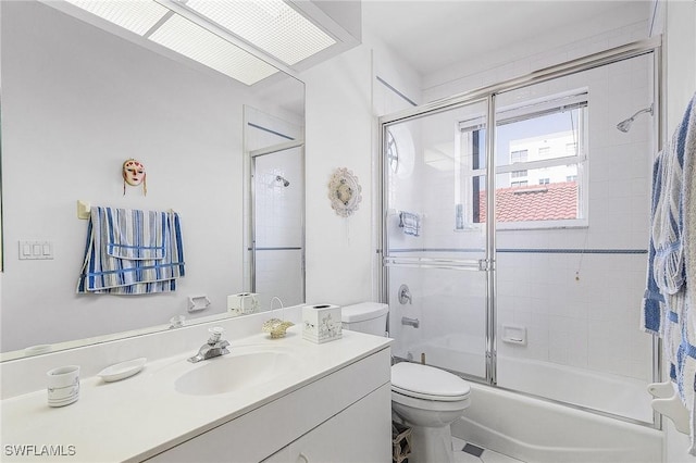 full bath featuring shower / bath combination with glass door, vanity, and toilet